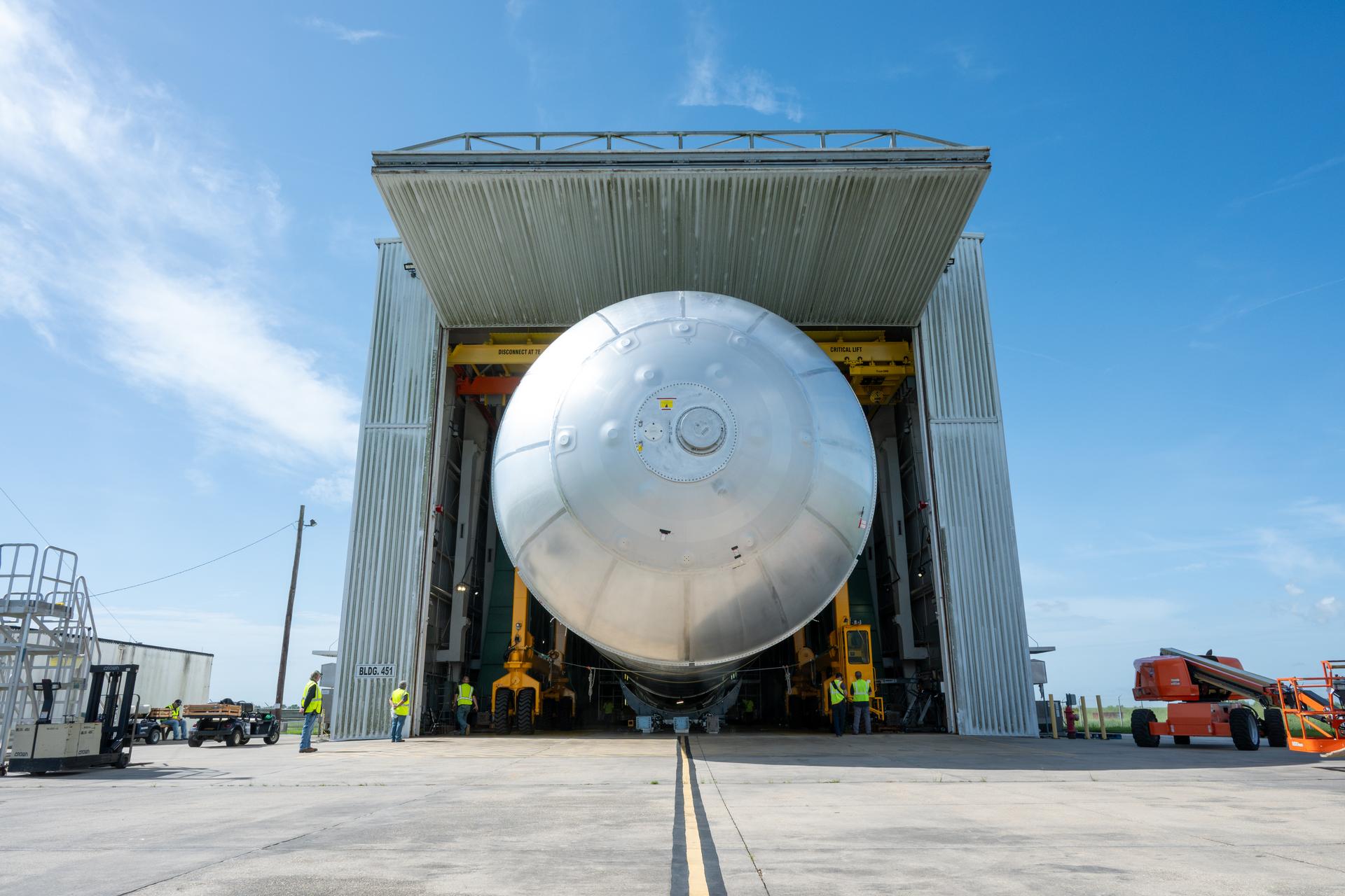 Crews at NASA’s Michoud Assembly Facility in New Orleans transport the 130-foot-tall liquid hydrogen tank from the proof testing building to the main factory on July 15. The liquid hydrogen tank will form part of the core stage for the SLS (Space Launch System) rocket for the agency’s Artemis IV mission, providing thousands of gallons of super-cold propellant to the rocket engines during launch. Soon, teams with SLS prime contractor, Boeing, will move the tank into the facility’s vertical assembly building for cleaning operations.   The liquid hydrogen propellant tank is one of five major elements that make up the 212-foot-tall SLS rocket stage. The core stage, along with its four RS-25 engines at its base, produce more than two million pounds of thrust to help launch NASA’s Orion spacecraft, astronauts, and supplies beyond Earth’s orbit and to the lunar surface for Artemis.      